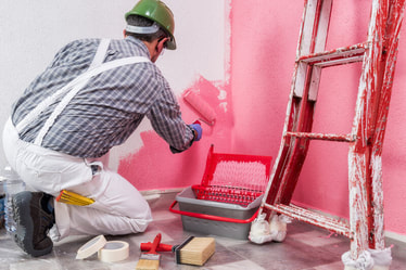Painter in Richmond applying pink paint to a wall